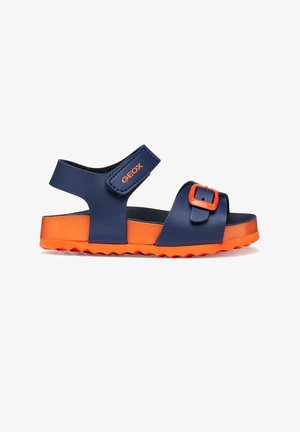 Sandalia infantil en azul marino y naranja brillante con tiras ajustables, cierre de velcro con la etiqueta "GEOX" y una suela texturizada.