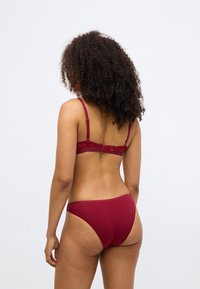 Bordo set donjeg rublja s čipkastim grudnjakom na leđima s podesivim trakama i odgovarajućim bikinijem s visokim strukom, od mekog pamuka.