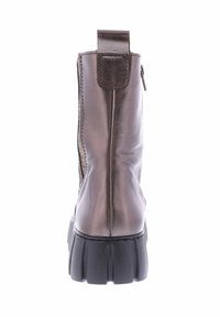 Brown leather ankle boot with a textured surface, a reinforcement patch at the heel, and a thick, black rubber sole.