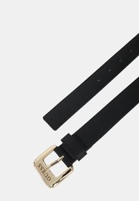 Schwarzer strukturierten Gürtel mit goldfarbener Metallschnalle, die das Wort "GUESS" zeigt. Verstellbar mit mehreren Löchern entlang des Riemens für die Größenanpassung.