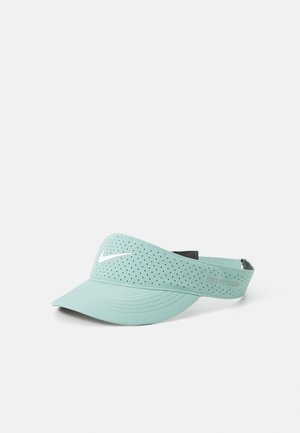 Fakó mentazöld napernyő sapka perforált mintával, ívelt karimával és fehér Nike logóval elöl. Hátul állítható pánt.