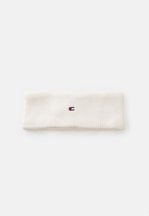 Faixa de cabelo branca em malha canelada com um pequeno logótipo em azul escuro, vermelho e branco. Feita de um material macio e texturizado. Design plano.
