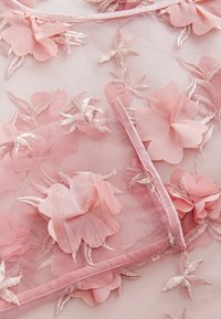 Rosa genomskinlig tyg med broderade blommönster. Innehåller satängblomsapplikationer och delikata metalltråd-accenter. Mjuk textur.