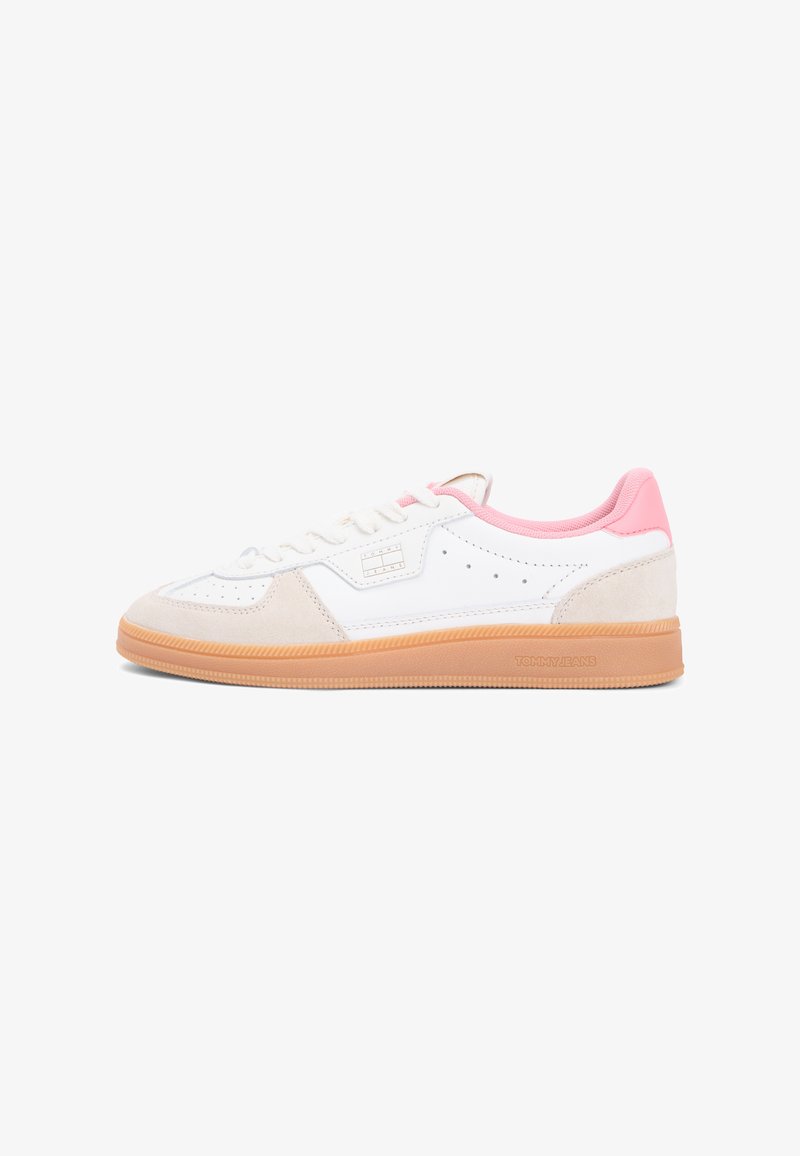 Baskets blanches avec des accents roses, bout en daim, détail perforé et semelle en caoutchouc gomme. Comprend des lacets et un logo sur le côté.