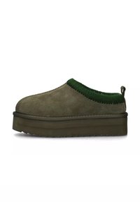 Scarpe slip-on in camoscio verde oliva con colletto in maglia verde testurizzata e suola platform spessa e segmentata. Caratterizzate da un tirante sul tallone.