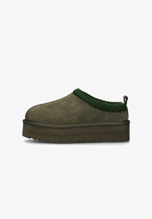 Scarpe slip-on in camoscio verde oliva con colletto in maglia verde testurizzata e suola platform spessa e segmentata. Caratterizzate da un tirante sul tallone.