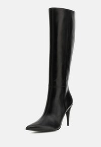 Černé vysoké kozačky vyrobené z hladké kůže, s špičatou špičkou a štíhlým jehlovým podpatkem. Minimalistický design bez viditelných ozdob.