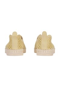 Scarpe slip-on beige con dettagli ritagliati, tomaia testurizzata e suola in gomma spessa. Marchio ben visibile sul tallone.