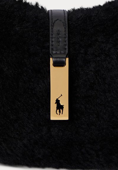 Melnas ādas somiņa ar zelta taisnstūra birku, uz kuras ir melns polo spēlētāja logotips, un melnu ādas siksnu nēsāšanai.