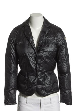 Glänzender schwarzer gesteppter Blazer mit drei Fronttaschen, präsentiert auf einer kopflosen Schaufensterpuppe mit weißen Hosen.