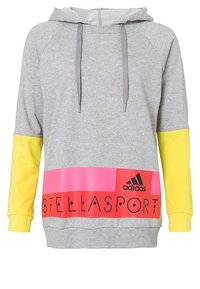 Sweat à capuche gris avec un ourlet arrondi, manches jaunes, panneau à rayures roses et rouges, et texte "STELLASPORT". Comprend des cordons de serrage et une poche kangourou.