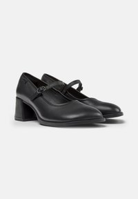 Pair of black leather Mary Jane shoes with round toes, adjustable strap with buckle, and block heels on a white background.