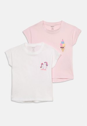 Deux t-shirts pour enfants à manches courtes, un blanc avec un petit imprimé licorne, un rose avec un petit cornet de glace portant des lunettes de soleil en forme de cœur.