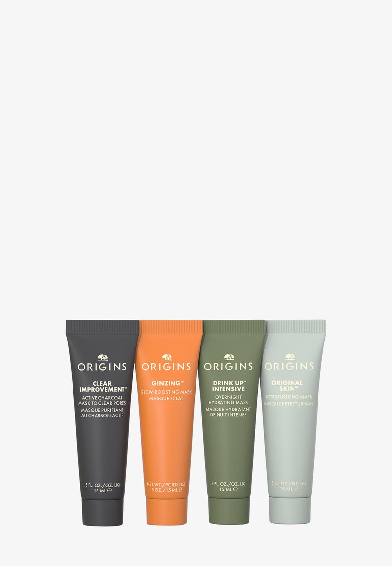 Cuatro tubos de cosméticos de Origins: negro (Clear Improvement), naranja (Ginzing), verde (Drink Up Intensive) y gris (Original Skin). Cada uno contiene 15 mL.