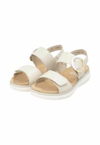 Sandales en cuir blanc avec deux larges sangles, une boucle ajustable sur le côté et une semelle intérieure rembourrée beige. Comprend une semelle extérieure blanche avec grip.