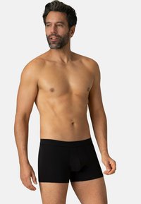 Boxers noirs en tissu doux et extensible, dotés d'une taille confortable et d'une coupe ajustée, adaptés à un port quotidien.