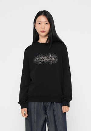 Svart sweatshirt med långa ärmar, ribbade mudd, med en glittrig "Karl Lagerfeld" logotypdesign på framsidan. Avslappnad passform.