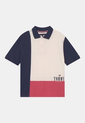 Kurzarm-Poloshirt in Marineblau, Creme und Rot. Verfügt über einen klassischen Kragen, eine Dreiknopf-Leiste und ein Logo, das am Saum aufgedruckt ist.