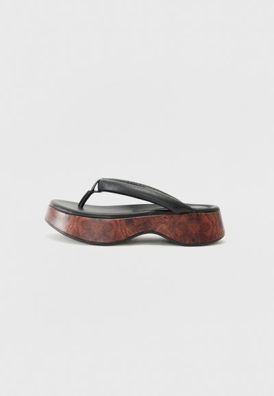 Sandalo infradito nero con una fascia in pelle texturizzata, piatto in legno sagomato e design della suola curva. Nota trama del legno sulla base.