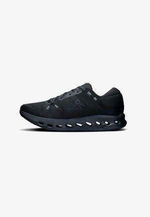 Black athletic sneakers with a mesh upper, circular cutouts in the sole, and a streamlined design. Features a reinforced toe cap and flat laces.