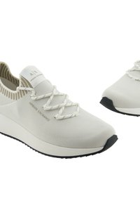 Scarpe slip-on bianche in maglia con una parte superiore texturizzata, lacci elastici e suola in gomma nera. Logo visibile sulla linguetta.