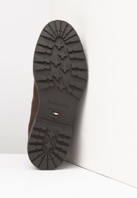 Brown shoe sole with traction pattern. Features cross-shaped lugs, flat heel, and embossed brand, Italian flag, and size details.