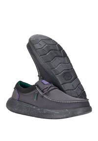 Zapatos de tela gris con una superficie texturizada, cuello negro en contraste, acentos morados y una suela de goma moteada con un patrón de banda.
