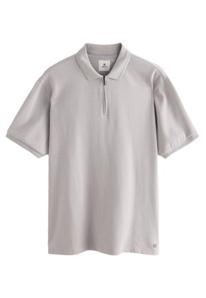 Hellgraues Poloshirt mit kurzen Ärmeln, strukturiertem Stoff, halbem Reißverschluss und geripptem Kragen. Dezentes Logo am Saum.