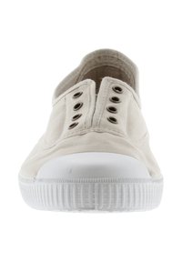 Scarpa slip-on in tela color crema con puntale in gomma bianca, caratterizzata da cinque occhielli metallici sui lati e suola testurizzata.