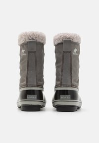 Graue Winterstiefel aus Textil und Gummi, mit einer gefütterten Oberseite aus Fell, flacher Sohle und geprägtem Logo auf der Rückseite.
