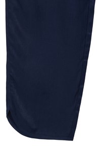 Tissu bleu marine foncé avec un ourlet droit et une petite fente sur le côté, montrant des détails de texture et de couture.