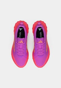 Pár fialových a červených sportovních bot s oranžovými akcenty a černými stélkami označenými jako „Ortholite“, pohled zhora na bílém pozadí.