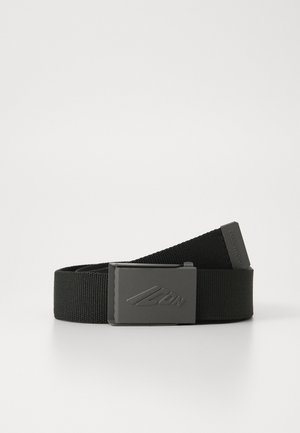 Ceinture en nylon noir avec une boucle en métal noir mat. La boucle présente un logo en relief. La ceinture a une texture lisse et robuste.