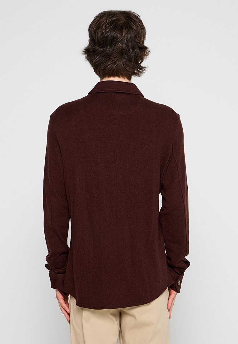 Bruine lange mouwen shirt met een kraag, gemaakt van een gestructureerde stof, met een recht afgeknipte zoom en met knoop manchetten.