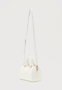 Λευκή τσάντα χειρός από λείο υλικό, με κοντές λαβές, αποσπώμενο λουράκι και διακοσμητικά στοιχεία σε χρυσό τόνο. Στρογγυλεμένο σχήμα και μινιμαλιστικός σχεδιασμός.