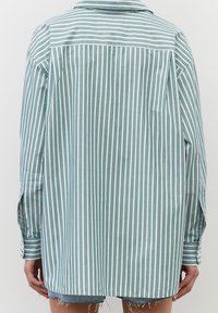 Camicia a righe con linee verdi, bianche e rosa, maniche lunghe e yoke sul retro, dal fit rilassato; realizzata in tessuto leggero.