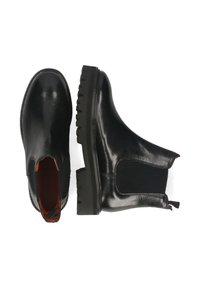 Botas Chelsea de piel negra con paneles laterales elásticos, suelas de tacos y tapas de tirón, mostradas desde vistas superior y lateral sobre fondo blanco.