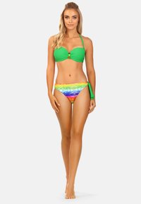 Zielony biustonosz bikini z dekoracyjnym zapięciem, w połączeniu z majtkami bikini w tęczowy wzór, z pomarańczowym i niebieskim gradientem. Gładka tkanina.