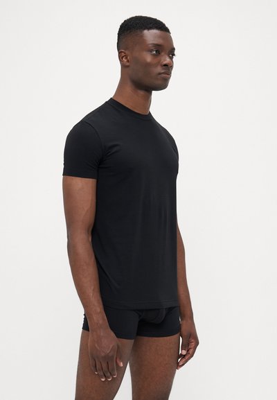 Sort kortærmet t-shirt lavet af glat stof, med rund halsudskæring og tætsiddende silhuet. Bæres med sorte boxershorts.