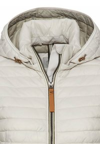 Gevoerde crèmekleurige jas met een capuchon, een ritssluiting aan de voorkant met een leren trekker en subtiele horizontale stiksels voor textuur. Hoge halsontwerp.
