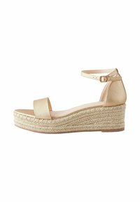 Sandale compensée espadrille beige avec une tige synthétique texturée, large sangle sur le devant, bride de cheville avec boucle et talon compensé recouvert de jute.
