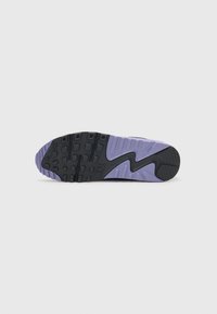 Black rubber outsole with purple accents, featuring a tread pattern and Nike logo; smooth and textured areas create visual contrast.