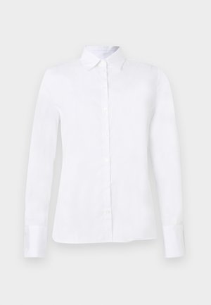 Valkoinen pitkähihainen nappipaita, jossa on terävä kaulus ja istuva siluetti, esitetty pelkällä vaaleanharmaalla taustalla.