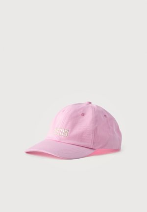 Gorra de béisbol rosa claro con letras blancas "GCDS" bordadas en la parte delantera, seis agujeros de ventilación y visera curva.