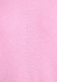 Ružová pletená látka s rebrovanou textúrou, so šikmým vzorom. Materiál pôsobí mäkko a mierne chlpatý.