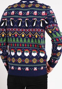 Navyblauer Strickpullover mit festlichen Mustern von Santa-Gesichtern, Pinguinen, Weihnachtsbäumen und Geschenken in lebhaften Farben. Gerippte Bündchen und Saum.
