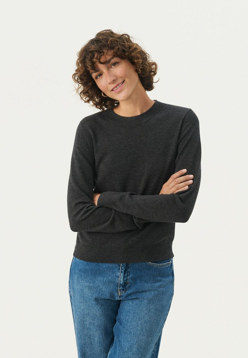 Kullersvær grå crewneck trøje i blødt stof med lange ærmer, tætsiddende manchetter og en afslappet pasform, parret med lyseblå denim jeans.