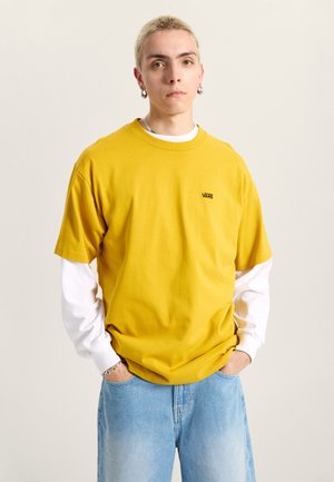 Geel katoenen t-shirt met een ronde halslijn en korte mouwen, gelaagd over een wit long-sleeve shirt. Bevat een klein logo op de borst.