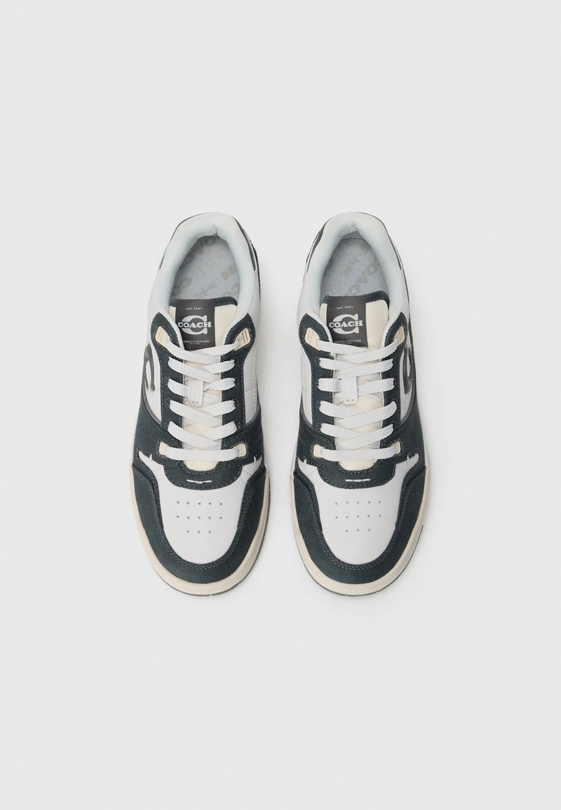 Sleek sneakers featuring a textured black and white upper, beige accents, and a classic lace-up design with perforated toe details.