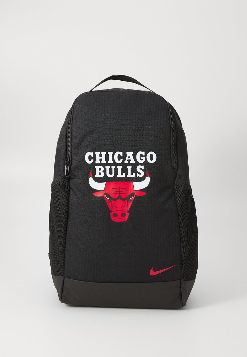 Crni ruksak od teksturirane tkanine s crvenim logotipom Chicago Bulls i bijelim natpisom. Uključuje bočnu mrežastu džep i Nike logotip.